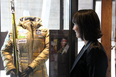 Marit Bjørgen foran monteret i Skimuseet med hennes gulljakke for VM-gullet på sprinten i Holmenkollen 2012, som samtidig var VM-gull nr. 100 for Norge. Foto: Skiforeningen.
