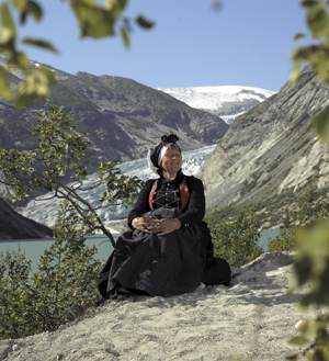 <br><i>Eit praktfullt panorama inn mot Nigardsbreen, ein arm av Jostedalsbreen. Drakta er i alle delar kopi av gamle plagg frå området rundt Jostedal. Dei gamle plagga er i samlinga til Breheimsenteret i Jostedal</i>