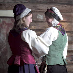 <br><i>Til livet er det mange ulike stoff og fargekvalitetar å velja mellom. Jenta til venstre har liv i mørkrosa silkedamask, mens jenta til høgre har liv i grøn ull/lin-kvalitet i damaskmønster</i>