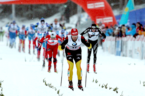 Tyskeren Axel Teichmann gikk klar av Dario Colognas fall like før oppløpet i jaktstarten på 2. etappen av Tour de Ski og kunne stake rolig inn til seier. Bak ser vi Petter Northug og Dario Cologna kjempe om 2. plass. Foto: Hemmersbach/NordicFocus. Tyskeren Axel Teichmann gikk klar av Dario Colognas fall like før oppløpet i jaktstarten på 2. etappen av Tour de Ski og kunne stake rolig inn til seier. Bak ser vi Petter Northug og Dario Cologna kjempe om 2. plass. Foto: Hemmersbach/NordicFocus.
