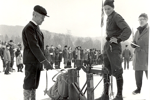 Erling Riddervold kontrollerer vekt på sekken under Birkebeinerrennet i 1950. Johan Haanes er eier av sekken. Eystein Raabe er funksjonær. Arrangørfoto. Erling Riddervold kontrollerer vekt på sekken under Birkebeinerrennet i 1950. Johan Haanes er eier av sekken. Eystein Raabe er funksjonær. Arrangørfoto.