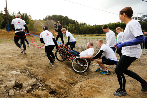 Cato Ulvestad med sitt følge på vei mot toppen ved Tryvannstårnet i rullestol under en tidligere utgave av motbakkeløpet Oslos Bratteste opp Wyllerløypa. Foto: Oslos Bratteste. Cato Ulvestad med sitt følge på vei mot toppen ved Tryvannstårnet i rullestol under en tidligere utgave av motbakkeløpet Oslos Bratteste opp Wyllerløypa. Foto: Oslos Bratteste.