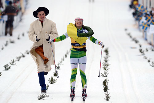 Laila Kveli har fått kransen av kransmas Daniel Svensson og går i mål som vinner av Vasaloppet 2014. Foto: Rauschendorfer/NordicFocus. Laila Kveli har fått kransen av kransmas Daniel Svensson og går i mål som vinner av Vasaloppet 2014. Foto: Rauschendorfer/NordicFocus.