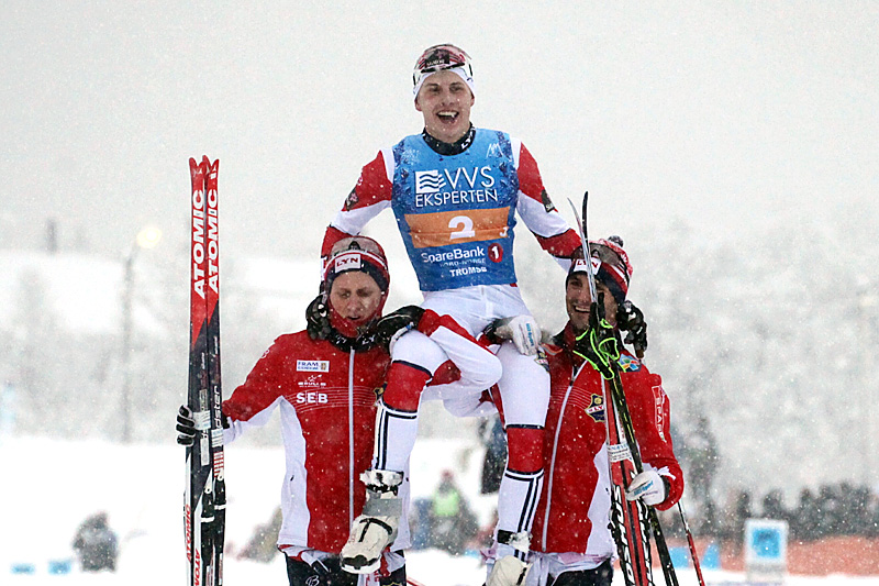 Simen Hegstad Krüger bæres på gullstol av lagkameratene Jonas Udjus Frorud (t.v.) og Hans Christer Holund etter at Lyn Ski ble norgesmestere på stafett i det tette snødrevet under NM i Tromsø 2016. Foto: Erik Borg. Simen Hegstad Krüger bæres på gullstol av lagkameratene Jonas Udjus Frorud (t.v.) og Hans Christer Holund etter at Lyn Ski ble norgesmestere på stafett i det tette snødrevet under NM i Tromsø 2016. Foto: Erik Borg.