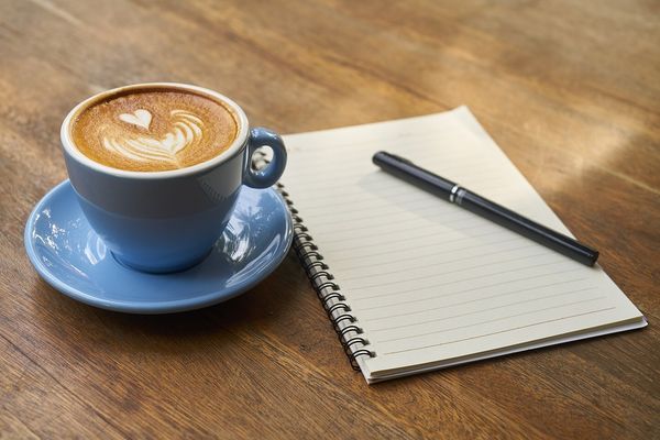 Kaffekopp og skriveblokk
