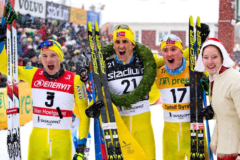 Den norske topptrioen i Vasaloppet 2019, alle fra Team Koteng. Fra venstre: Stian Hoelgaard (2. plass), Tore Bjørseth Berdal (1), Torleif Syrstad (3) og kranskullan. Foto: Manzoni/NordicFocus. Den norske topptrioen i Vasaloppet 2019, alle fra Team Koteng. Fra venstre: Stian Hoelgaard (2. plass), Tore Bjørseth Berdal (1), Torleif Syrstad (3) og kranskullan. Foto: Manzoni/NordicFocus.