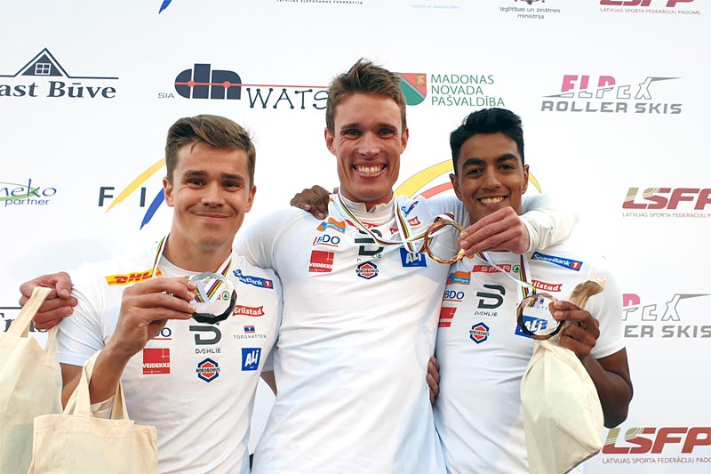 Gullvinneren Ragnar Bragvin Andresen flankeres av Jostein Olafsen (2. plass) og Kristian Ankersen (3) etter sprinten i rulleski-VM i Latvia 2019. Foto: Norges Skiforbund. Gullvinneren Ragnar Bragvin Andresen flankeres av Jostein Olafsen (2. plass) og Kristian Ankersen (3) etter sprinten i rulleski-VM i Latvia 2019. Foto: Norges Skiforbund.