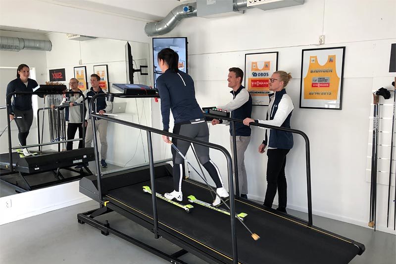 Holmenkollen Treningslab med Marit Bjørgen på treningsmølla, ringside står Ragnar Bragvin Andresen og Sondre Sundby. Foto: Holmenkollen Treningslab. Holmenkollen Treningslab med Marit Bjørgen på treningsmølla, ringside står Ragnar Bragvin Andresen og Sondre Sundby. Foto: Holmenkollen Treningslab.