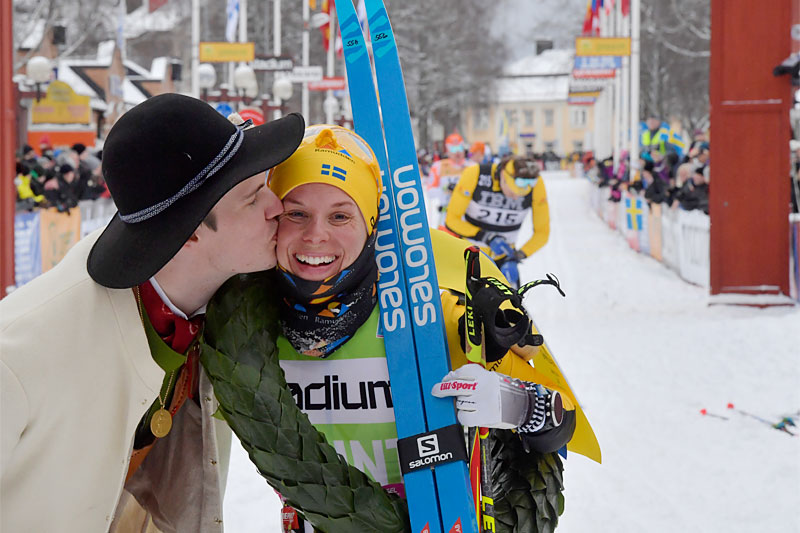 Lina Korsgren vant Vasaloppet 2020 i suveren stil og får her seierskransen og seierskysset fra den såkalte kransmasen. Foto: Schmidt / NordicFocus. Lina Korsgren vant Vasaloppet 2020 i suveren stil og får her seierskransen og seierskysset fra den såkalte kransmasen. Foto: Schmidt / NordicFocus.