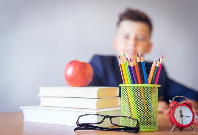 Bildet viser en elev med skolebøker på pulten