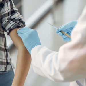 Bilde av helsepersonell som setter vaksine på pasient