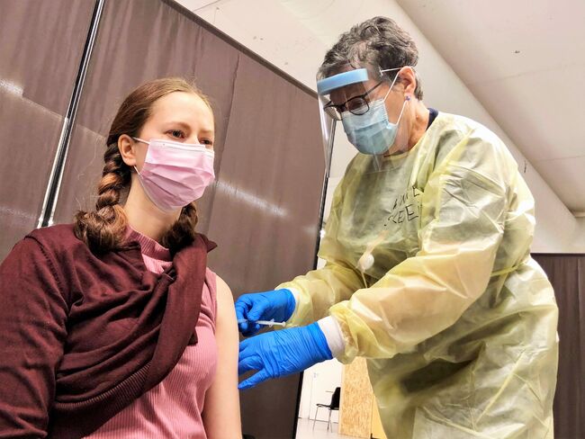 Bildet viser ei kvinne som får vaksine mot Covid-19.
