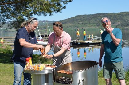 Fornøyde kommunestyrerepresentanter og ordfører åpner offisielt den nye grillplassen på Nøklebytangen (foto: Anette Skafjeld) Bildet viser kommunstyrerepresentantene Bård Bobby Brørby, ordfører Morten Lafton og Harald Antonsen spise pølser.