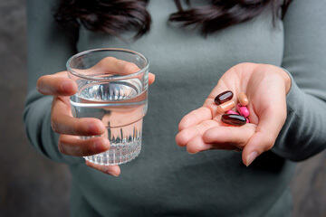 bs-Woman-Holding-Pill-412356103-360
