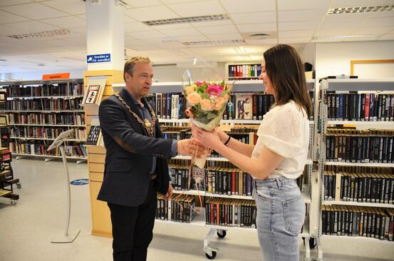 Bildet viser ordfører overrekke blomster til bibliotekleder i anledningen åpningen av selvbetjent bibliotek.