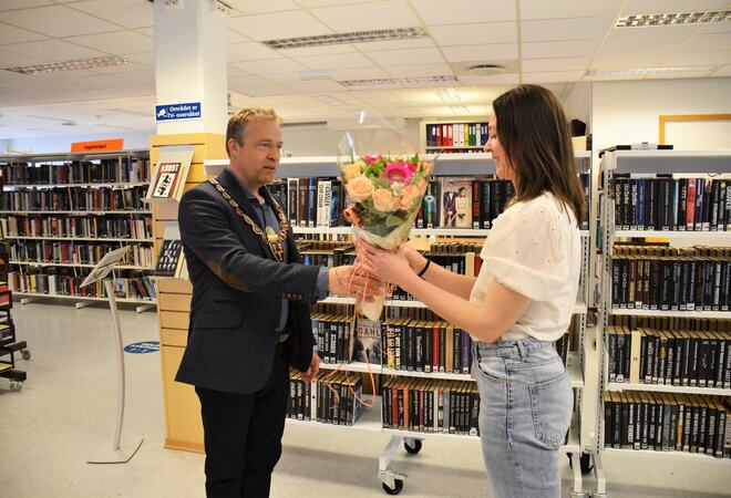 Bildet viser ordfører overrekke blomster til bibliotekleder i anledningen åpningen av selvbetjent bibliotek.