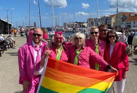 Rosakledde musikanter med Pride-flagg. Foto.