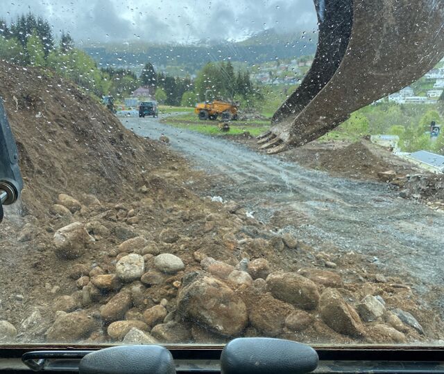 SPENNENDE UTSIKTER: Fra førersetet i sin åtte tonns gravemaskin av merket New Holland Kobelco e70sr, gjør Helge Ibrahim grovjobben for det han håper skal bli et nytt og unikt feriekonsept ved Stranda Feriesenter. (Foto: Helge S. Ibrahim)
