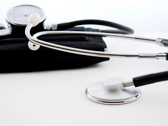 Illustrasjonsbilde som viser stetoskop og blodtrykksmåleapparat liggende på et bord.