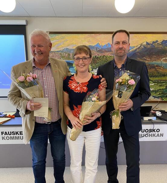 To menn og en kvinne står ved siden av hverandre med hver sin blomsterbukkett