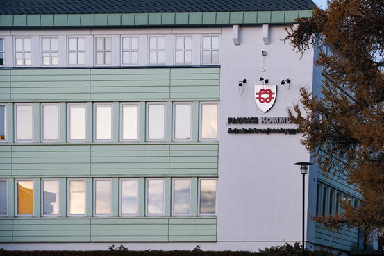 Hvitt bygg med kommunevåpen Fauske kommune og teksten administrasjonsbygget