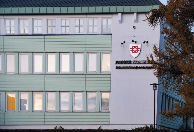 Hvitt bygg med kommunevåpen Fauske kommune og teksten administrasjonsbygget