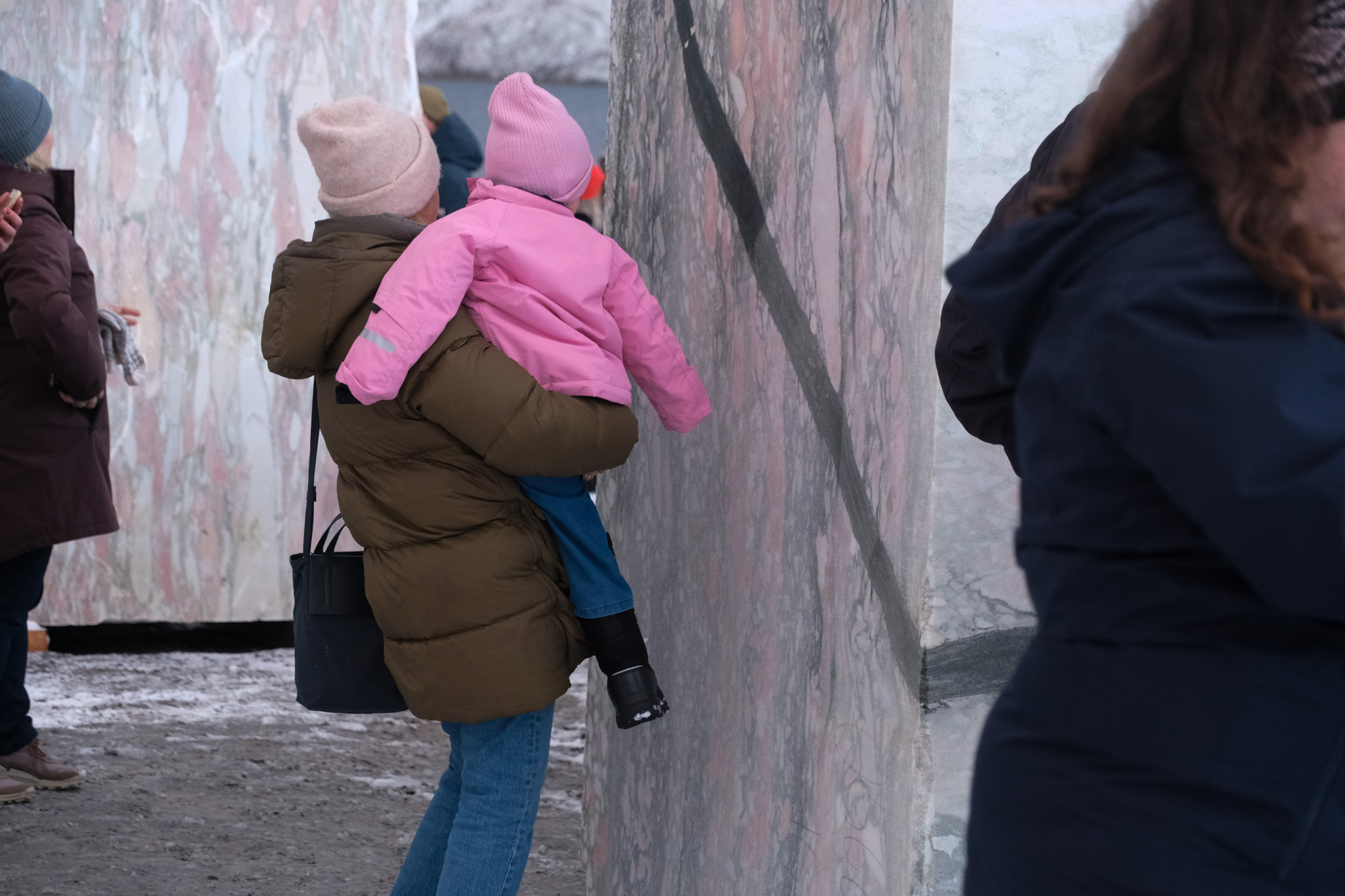 En kvinne holder på et barn mens de studerer marmoren