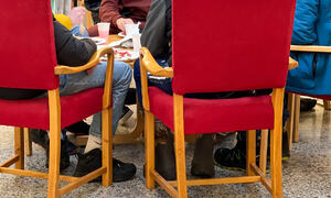 Elever sitter rundt et bord og spiser