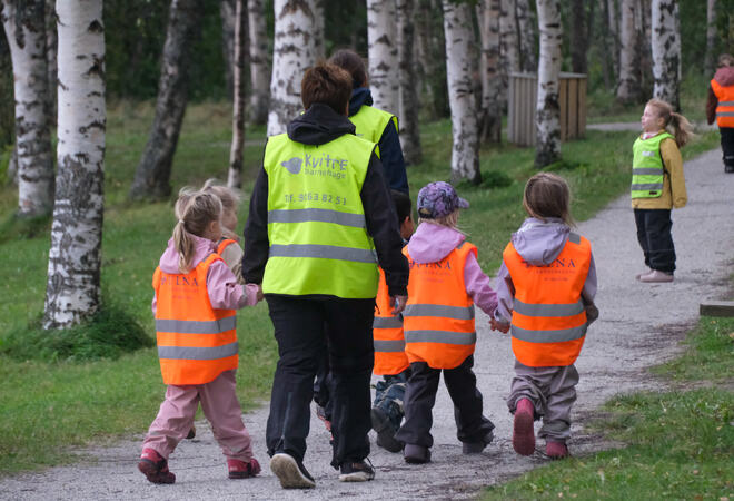 Barn går på en sti på bygdetunet sammen med voksen