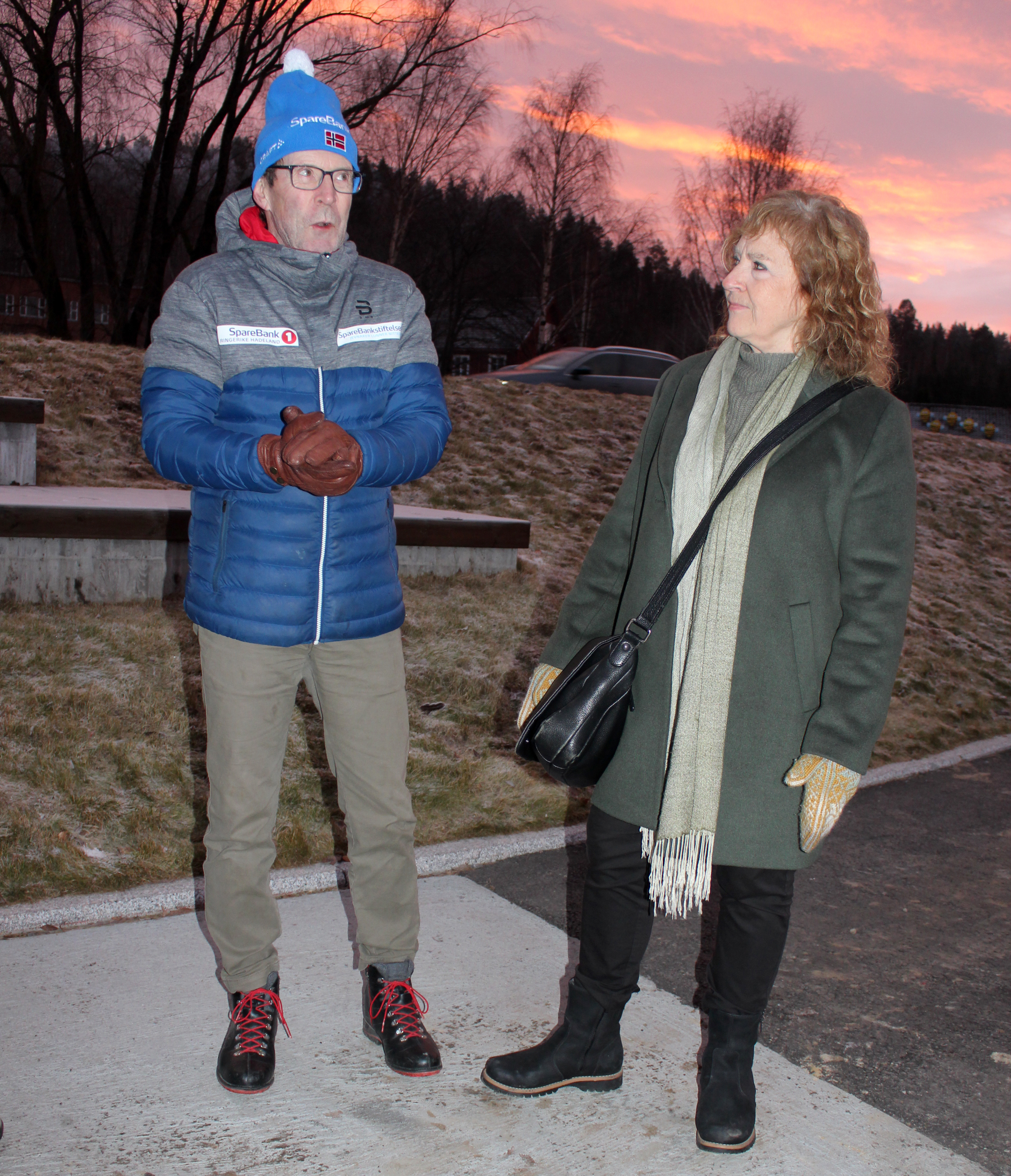 Bildet viser to personer som står ved siden av hverandre og prater.