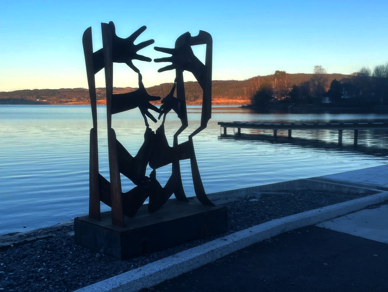 Bildet viser en skulptur med armer og bein som strekker seg inn mot hverandre.