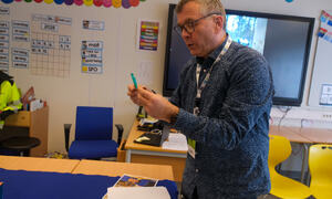 Mann leser en lapp og smiler.