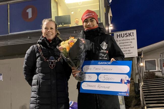 Bildet viser to personer. Hun til venstre har ordførerkjede. Han til høyre holder blomst og sjekk.
