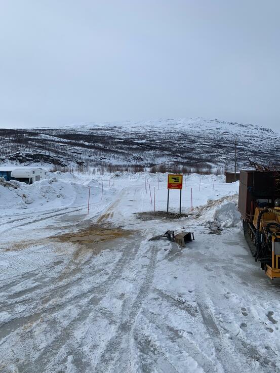 Stort område med litt snø. Skilt med helikopterlandingsplass