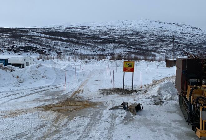 Stort område med litt snø. Skilt med helikopterlandingsplass