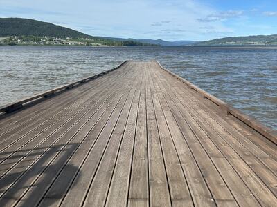 Bildet viser ei trebrygge, med Randsfjorden på tre kanter. Det er nesten blå himmel.