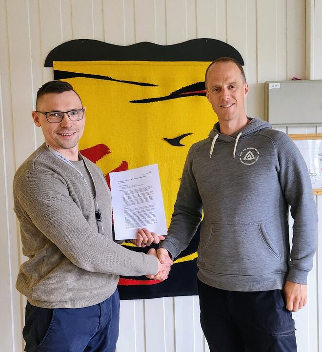 Dan Robert Svenske (t.v.) og Daniel Mood (t.h.) signerer samarbeidsavtalen om Perleturhytta på Toppenfjellet. Foto: Sør-Varanger kommune.