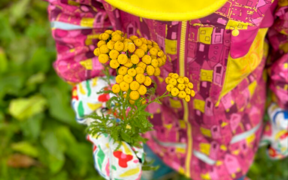 Barn med regnjakke og gule blomster Renee B