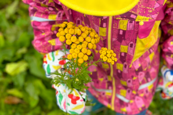Barn med regnjakke og gule blomster Renee B