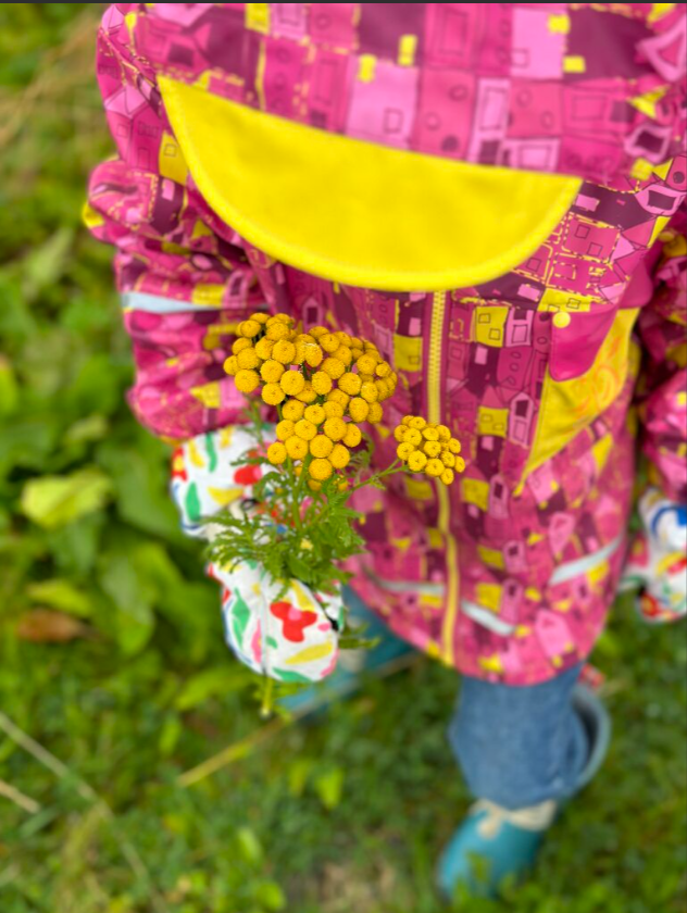 Barn med regnjakke og gule blomster Renee B